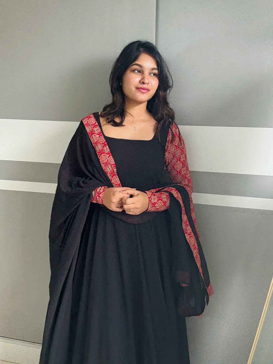 stunning portrait of a young woman exuding grace and poise in a traditional black Anarkali outfit.(JORJET)